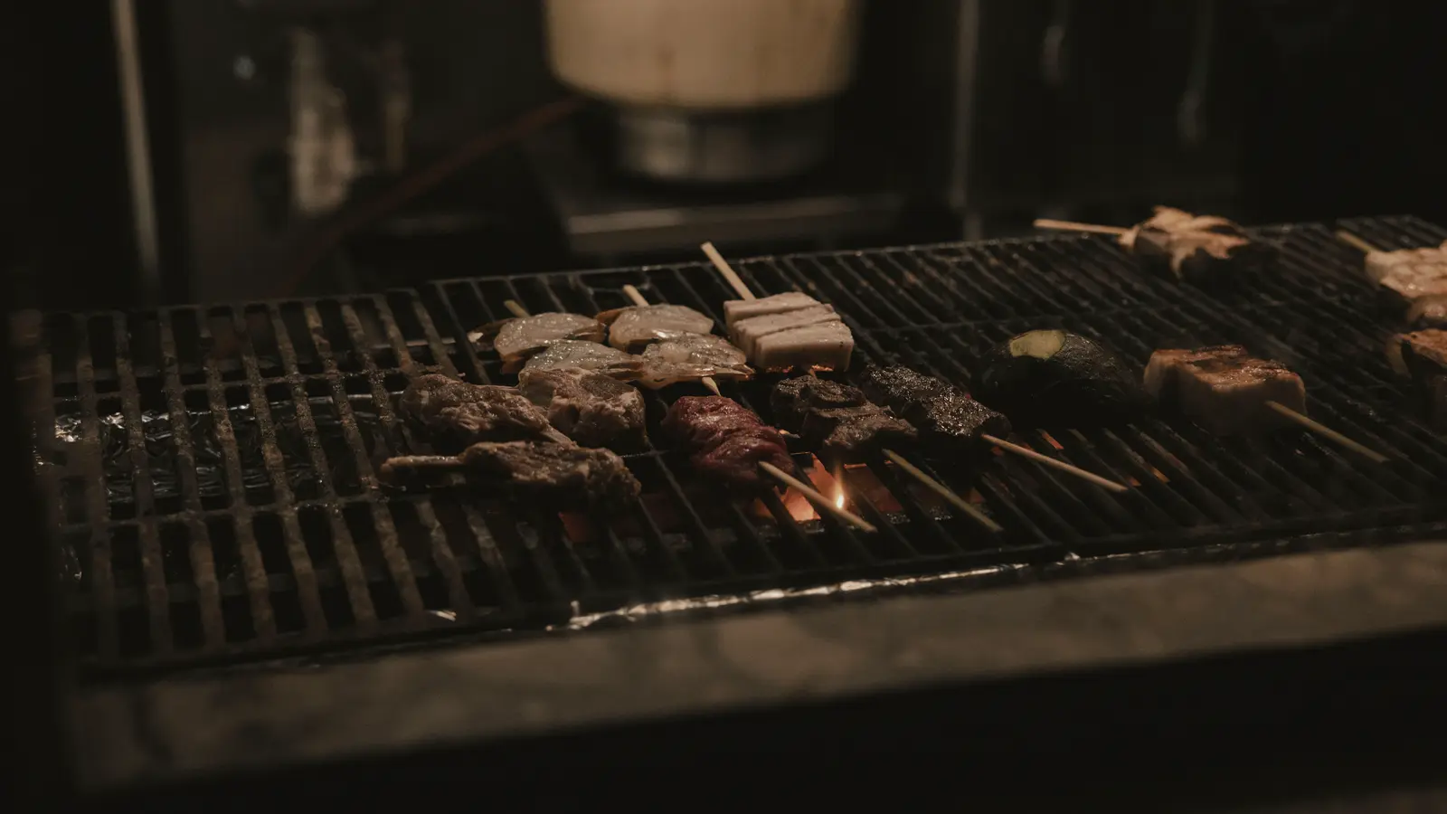 숯불 위에 고기와 해산물 꼬치가 올라간 그릴